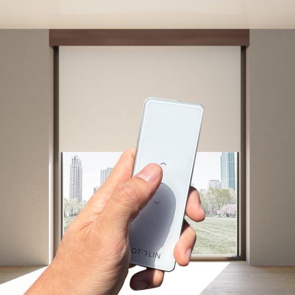 Hand clicking on single-channel, Fabtex handheld remote for roller shade. In the background is blackout shade.