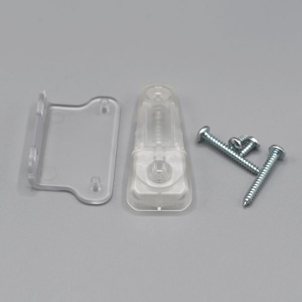 A clear, unassembled Fabtex chainhold tension device for roller shades showing the mounting brackets, tension device, and screws.